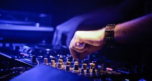 dj音乐网收录的Dubstep混音师在电子设备前创作，蓝紫光线氛围强烈的暗调画面